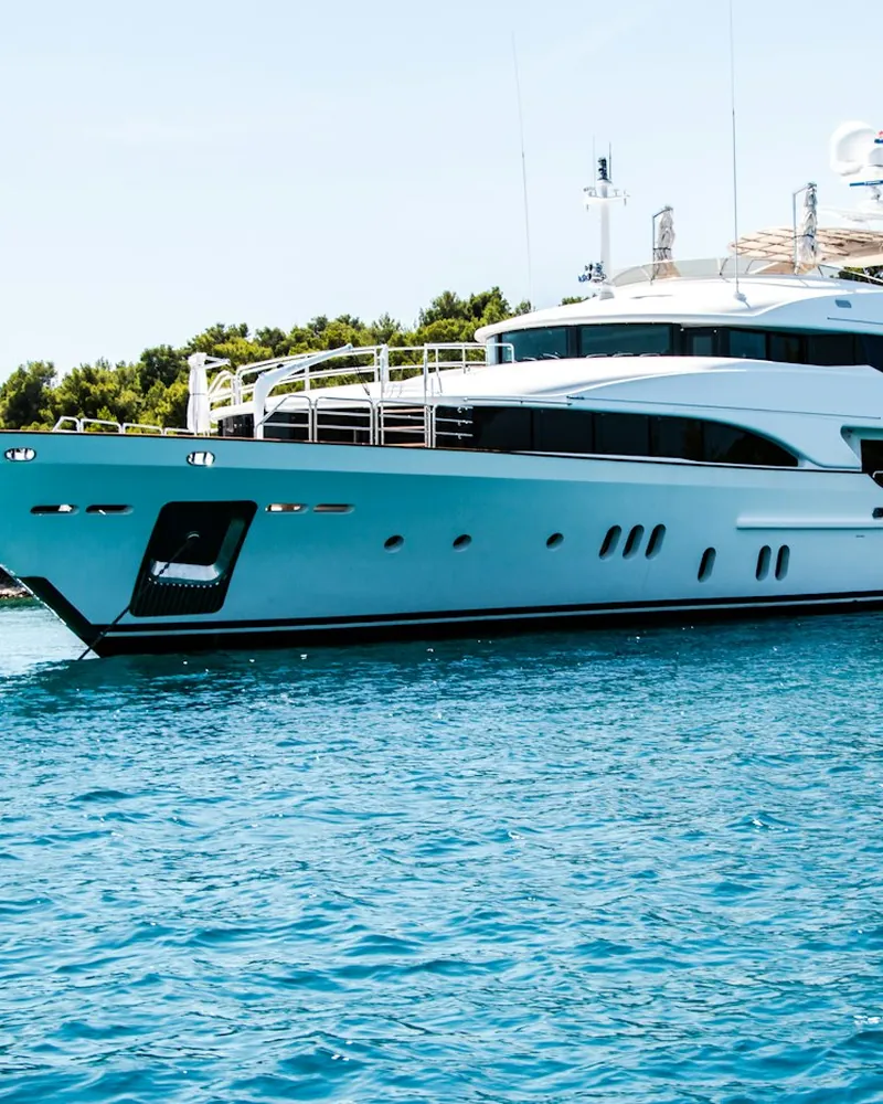 Large white motor yacht anchored in a bay
